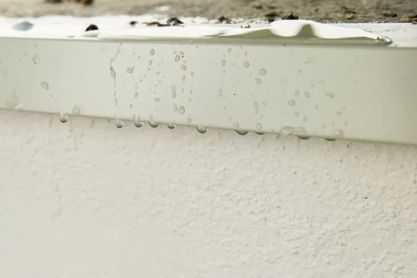 Dónde instalar goterones: Fotografía de cerca del marco de una ventana con goterón metálico color blanco.